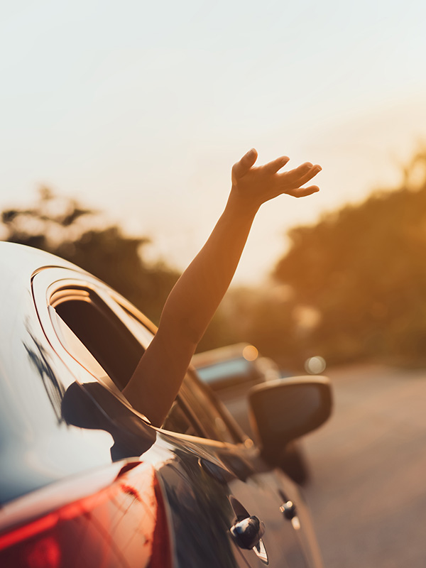 Person hält Arm aus Autofenster